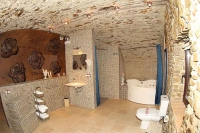 De color terra i beige. Un cuarto de bany molt espais i original. Disposa de Bany Hidromassatge i Dutxa. Detall molt curis es el pou del trull doli dins el cuarto de bany.