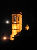 De nit, el campanar de l'esglsia parroquial documentada des del segle XIV.